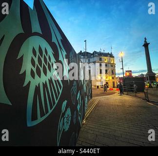 Bauten mit den Blumen des Vereinigten Königreichs und der Nelson-Säule zur Vorbereitung der Krönung von König Karl III. In London Stockfoto