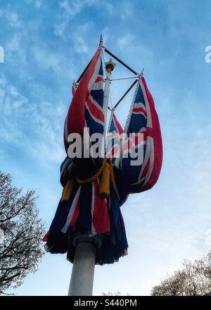 Die Union Jack oder die Gewerkschaftsflagge des Vereinigten Königreichs befindet sich auf einem Fahnenstab in der Mall in London - gefaltet, bereit für die Krönung von König Karl III - oben ist eine neu bemalte Krone Stockfoto