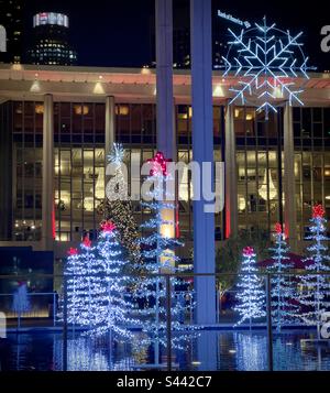 LOS ANGELES, Kalifornien, 2022. DEZEMBER: Weihnachtsbäume und Weihnachtsdekorationen werden nachts im Music Center in Downtown mit LEDs beleuchtet. Wolkenkratzer im Hintergrund sichtbar Stockfoto