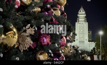 LOS ANGELES, CA, 2022. DEZEMBER: Details des Weihnachtsbaums im Vordergrund, dekoriert für die Feiertage im Music Center in Downtown. Rathaus im Hintergrund, nachts beleuchtet Stockfoto