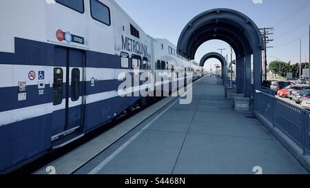 BURBANK, CA, DEZ. 2022: Metrolink-Zug fährt in Kürze vom Stadtbahnbahnhof am Burbank Airport ab, früher bekannt als Bob Hope Airport. Tagesansicht entlang der Plattform Stockfoto