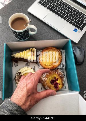 Versuchung Auswahl an Kuchen, Kaffee und Kuchen Pause bei der Arbeit, Arbeit von Home Office wfh Stockfoto