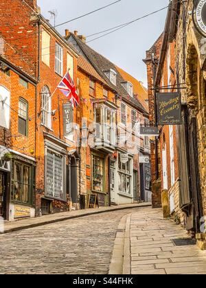 Alte Geschäfte und Kopfsteinpflaster. Historischer Steiler Hügel, Lincoln, Lincolnshire, England. Stockfoto