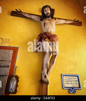 Eine Skulptur von Jesus Christus, gekreuzigt auf einer gelben Wand, schmückt die Basilika de Nuestra Señora de los Dolores de Soriano in. Dickdarm, Queretaro, Mexiko Stockfoto
