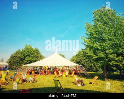 Gäste genießen den Sonnenschein am 2. Tag des Hay Festivals in Wales. Freitag, 26. Mai 2023. Stockfoto
