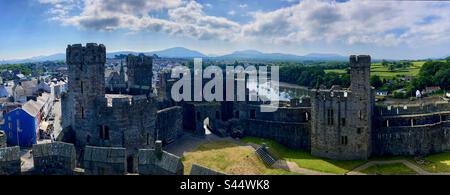 Blick vom Turm des Caernarfon Castle mit Fluss, Booten und Snowdonia-Bergen im Hintergrund Stockfoto