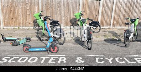 E Fahrräder und Elektroroller in einer Bucht geparkt Stockfoto