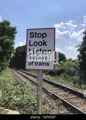 Halten Sie Ausschau, hören Sie zu, Warnschild an einer Bahn in London, England Stockfoto