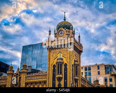 Niedriger Winkel mit Blick auf den Uhrenturm und die Minarette des Forum-Theaters in Melbourne, Victoria, Australien, vor dem wolkigen blauen Himmel. Maurische Revival-Architektur. 1929 erbaut. Kulturerbe. Stockfoto