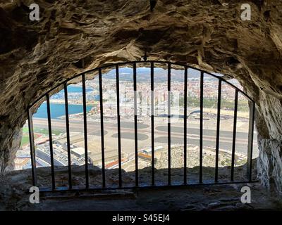 Ein ungewöhnlicher Blick auf den Flughafen von Gibraltar und das spanische Festland dahinter von einem der vielen Tunnel hoch oben auf dem Felsen von Gibraltar Stockfoto