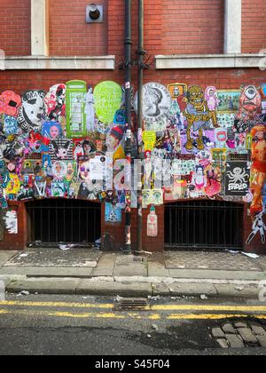 Fliegenposter an einer Wand in einer Seitenstraße im nördlichen Viertel von Manchester. Stockfoto