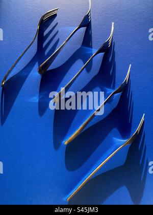 Isolierter Gabelsatz auf blauem Hintergrund mit dramatischem natürlichem Licht Stockfoto