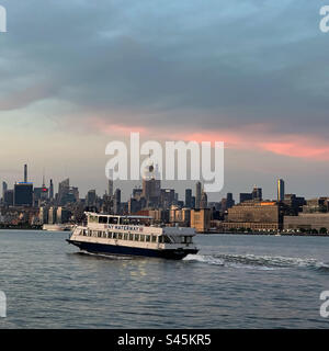 Blick auf den Sonnenuntergang auf eine NY Waterway Fähre, die von Jersey City, New Jersey, nach Manhattan, New York, New York, Vereinigte Staaten Stockfoto