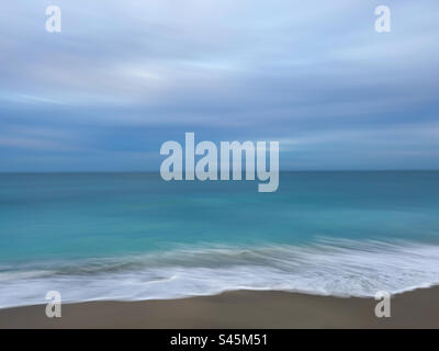 Abstrakter bewölkter Strandtag mit grünem und blauem Meer. Stockfoto