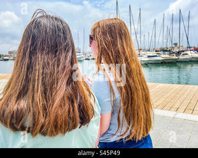 Zwei junge Frauen, die im Hafen von Alicante in Spanien spazieren Stockfoto