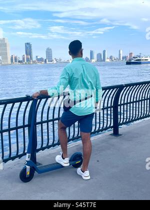 Ein junger Mann, der über den East River in New York City schaut. Stockfoto