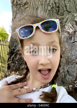 Neunjähriges Mädchen im Freien mit einem überraschenden Gesichtsausdruck. Stockfoto