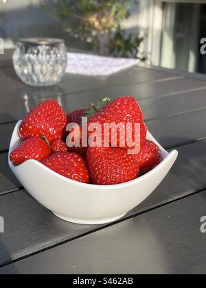 Erdbeeren in einer Tasse auf einem Holztisch Stockfoto