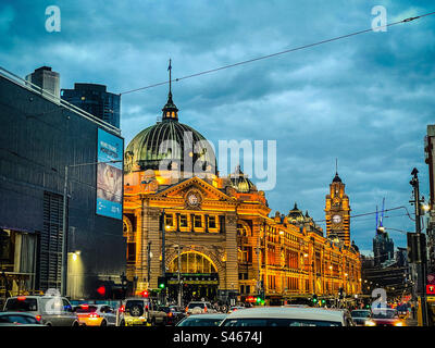 Bahnhof Flinders Street, Stadtgebäude und überfüllte Straße im Geschäftsviertel von Melbourne, Victoria, Australien, vor dem wolkigen blauen Himmel bei Sonnenuntergang im Winter. Stockfoto