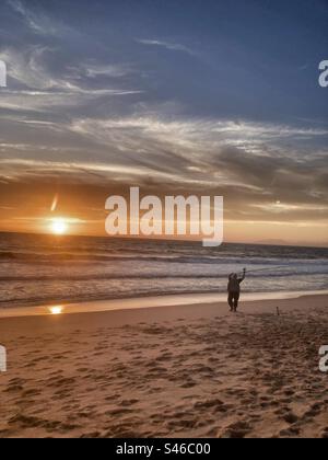 Portugiesischer Fischer bei Sonnenuntergang am Lagoa de Albufeira Strand (Sesimbra Region, Setubal County, südlich von Portugal). Stockfoto