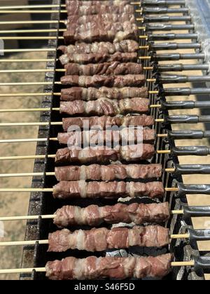 Arrosticini, traditionelle Gerichte mit gegrilltem Fleisch, typisch für Molisana und die abruzzesische Küche, hergestellt aus Hammel- oder Lammfleisch, in Stücke geschnitten und von einem Spieß durchbohrt Stockfoto