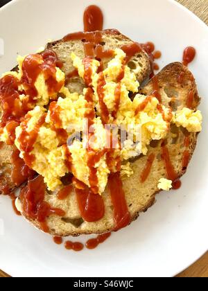 Rührei auf Sauerteigtoast mit Tomatensoße Stockfoto