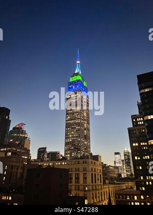 Blau-weiß-grüne Tower Lights auf dem Empire State Building zu Ehren des 30-jährigen Jubiläums von Extra TV am 6. September 2023 in New York City, USA Stockfoto