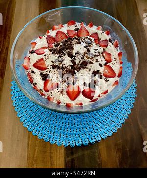 Kleines Dessert aus Eis, Erdbeeren, Schlagsahne und Schokoladenspänen. Stockfoto