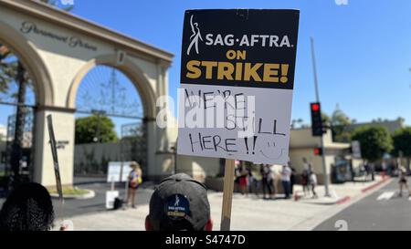 LOS ANGELES, CA, 30. Juni 2023: Schlagzeuger mit sag-AFTRA-Schild mit der Aufschrift „We're still Here“, während er vor Paramount Pictures in Hollywood spielt Stockfoto