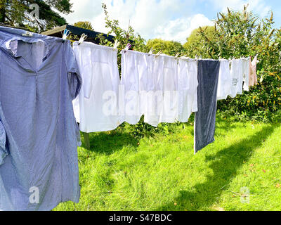 Wäscheständer, die an einer Wäscheleine hängen, trocknen in einem Hintergarten. Stockfoto