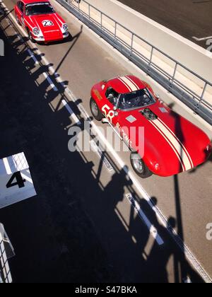 1960s Cobra & Porsche 911 in der Boxengasse auf Goodwood Motor Racing Circuit UK Stockfoto