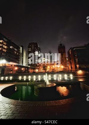 St. Giles' Cripplegate im Herzen des Barbican-Anwesens - eine mittelalterliche Kirche in einem brutalistischen architektonischen Komplex aus Wohnhäusern und kulturellen Einrichtungen, die nachts gesehen werden Stockfoto