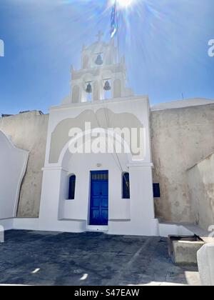 Die heiße und helle Sommersonne scheint an einem Sommertag auf dem Glockenturm der Kirche Saint Paraskevi h in Megalochori, Santorin. Stockfoto