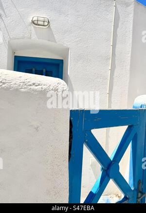 Blaues Tor und Tür in einem weiß getünchten Gebäude im Dorf Megalochori auf der Insel Santorin. Stockfoto