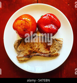 Ein gegrilltes New Yorker Steak, eine rote Tomate und eine rote Paprika auf einem Teller in Mexiko Stockfoto