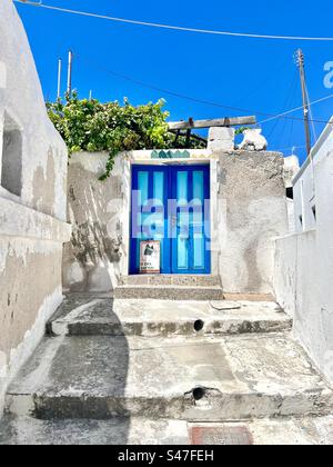 Zweifarbige blaue Tür in einem weiß getünchten Gebäude, Santorin. Stockfoto