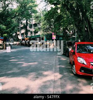 Autos und Auto-Rikschas parken auf einer Straße in Mumbai, Indien Stockfoto