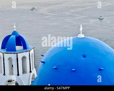 Nahaufnahme der blauen Kuppelkirche und des Glockenturms mit blauer Kuppel in Oia, Santorin. Stockfoto