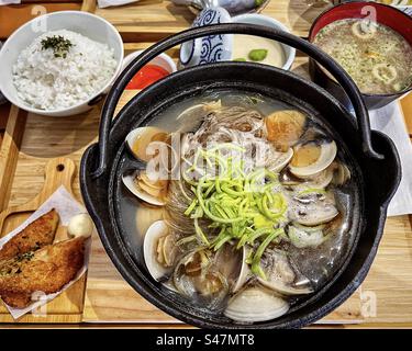 Blick aus einem hohen Winkel auf das japanische bento-Mittagessen: Muscheln und Vermicelli in Hotpot, Reis, Miso-Suppe, Kartoffelbraun und Chawan-Mushi/gedämpfte herzhafte Eiersuppe. Japanisches Essen. Tradition. Mittagessen. Stockfoto