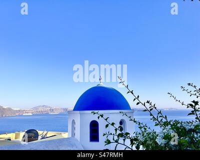 Panagia Agion Panton, blaue Kuppelkirche in Oia, Santorin mit der Ägäis dahinter. Stockfoto