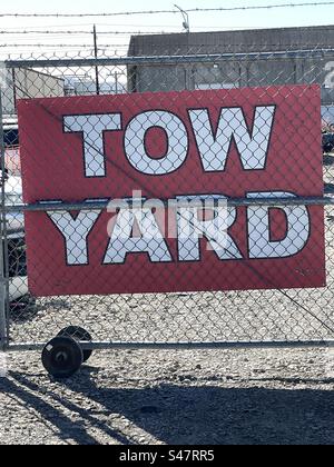 Abschlepptor und Stacheldrahtzaun mit Schildern, die dieses Lagergut als Abschleppplatz kennzeichnen. Stockfoto