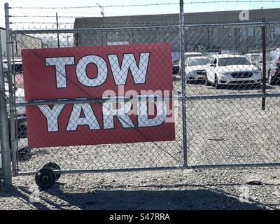 Abschlepptor und Stacheldrahtzaun mit Schildern, die dieses Lagergut als Abschleppplatz kennzeichnen. Stockfoto