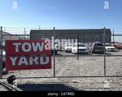 Abschlepptor und Stacheldrahtzaun mit Schildern, die dieses Lagergut als Abschleppplatz kennzeichnen. Stockfoto