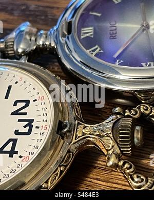 Zwei unterschiedlich gestaltete Taschenuhren zeigen die Zeiten im Stillleben. Stockfoto