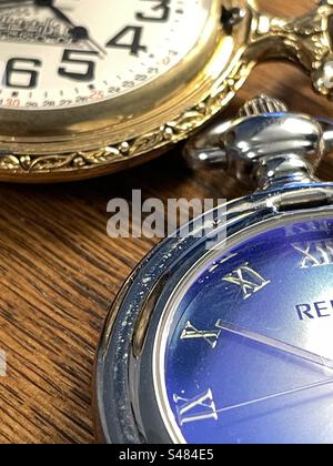 Zwei unterschiedlich gestaltete Taschenuhren zeigen die Zeiten im Stillleben. Stockfoto