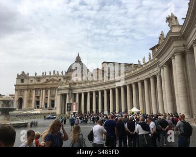 Fila di turisti e pellegrini pro visitare la Basilica di san Pietro. Vaticano, Rom. Colonnato di destra. Veduta parziale della Basilica, Cupola. Stockfoto