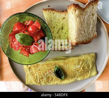 Omelette, frische Tomaten und Brotfrühstück Stockfoto