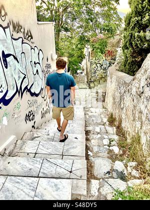 Gehen Sie eine enge Straße mit steilen Stufen hinunter im Stadtteil Plaka von Athen Stockfoto