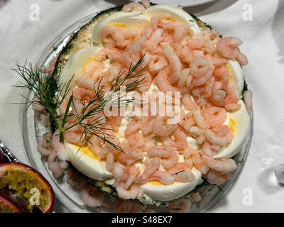 Traditioneller schwedischer Smörgåstårta (schwedischer Sandwichkuchen) mit Garnelen und hart gekochtem Ei. Stockfoto