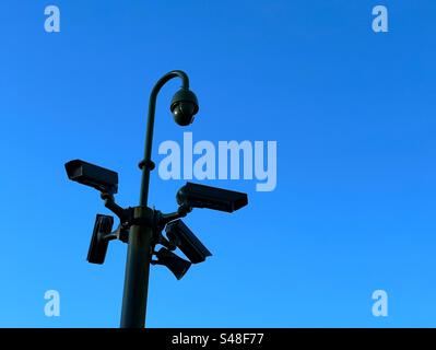 CCTV-Kameras in Schwarz vor einem leuchtend blauen Himmel. Im Haigh County Park, Wigan Stockfoto